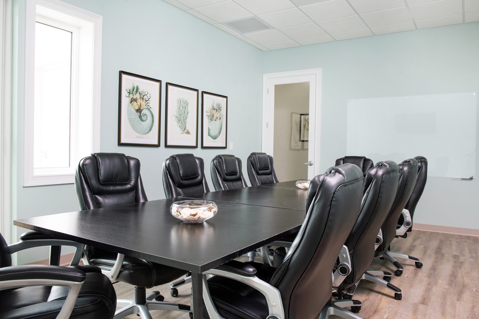 Conference room table with natural light and glass whiteboard